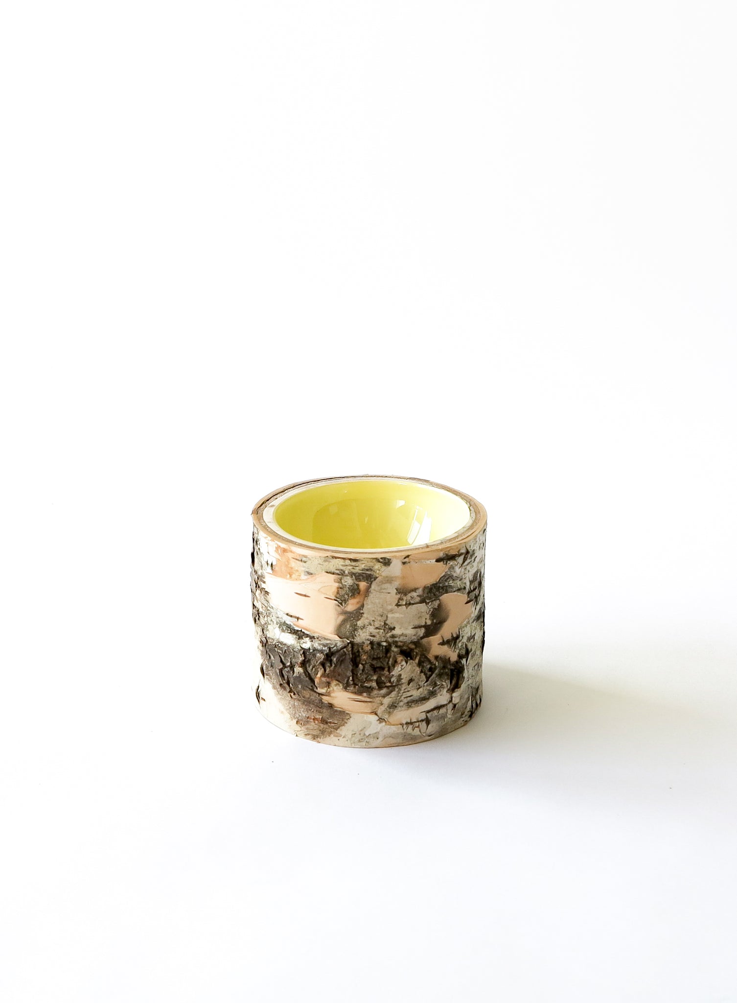 Alternative angle of Size 3 Log Bowl - small wooden bowl with papery birch bark, glossy interior is a butter yellow colour.
