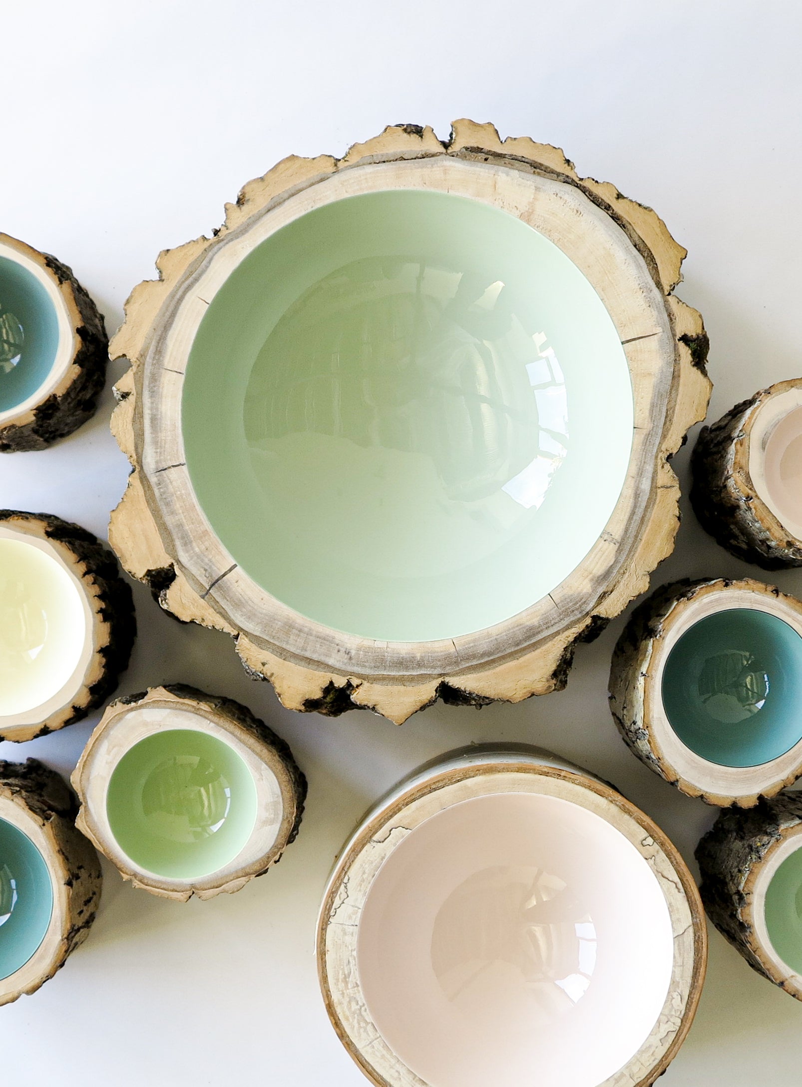 Top view of Eucalyptus size 11 extra large wooden Log Bowl by Loyal Loot mixed in a group of Log Bowls in various pastel colours.