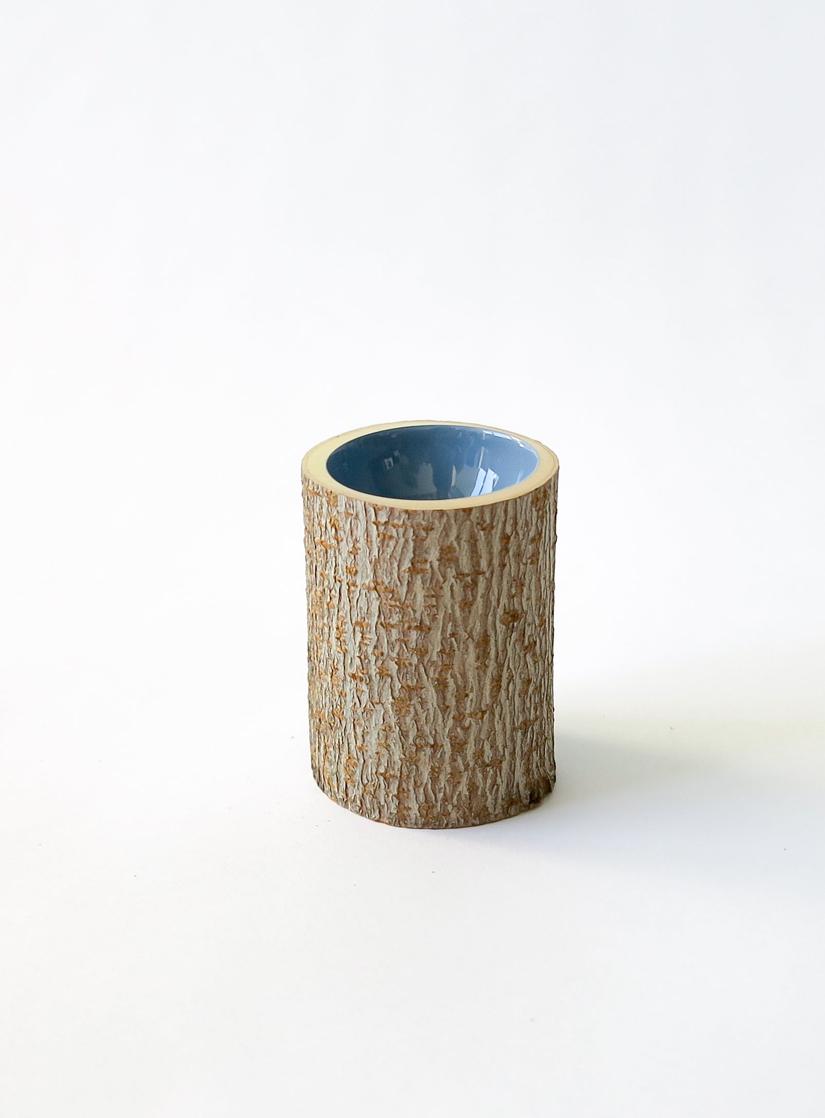 Close up view of Size 2 Log Bowl - extra small wooden bowl with rough bark, glossy interior is a dusty denim blue colour.