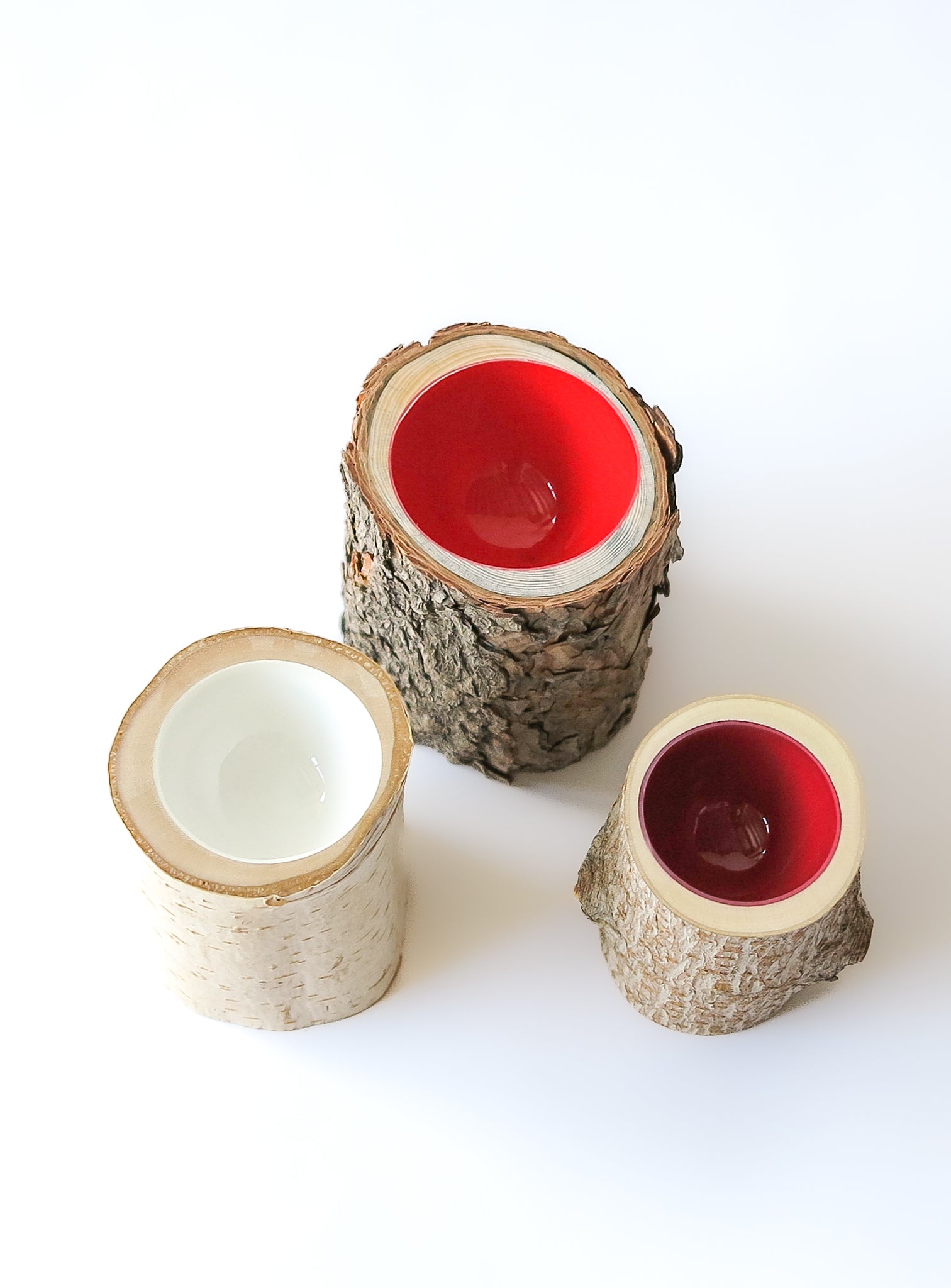top view of Size 2 Log Bowls - 3 small wooden bowls with various barks, glossy interiors are bright red, dark current red and white in colour.