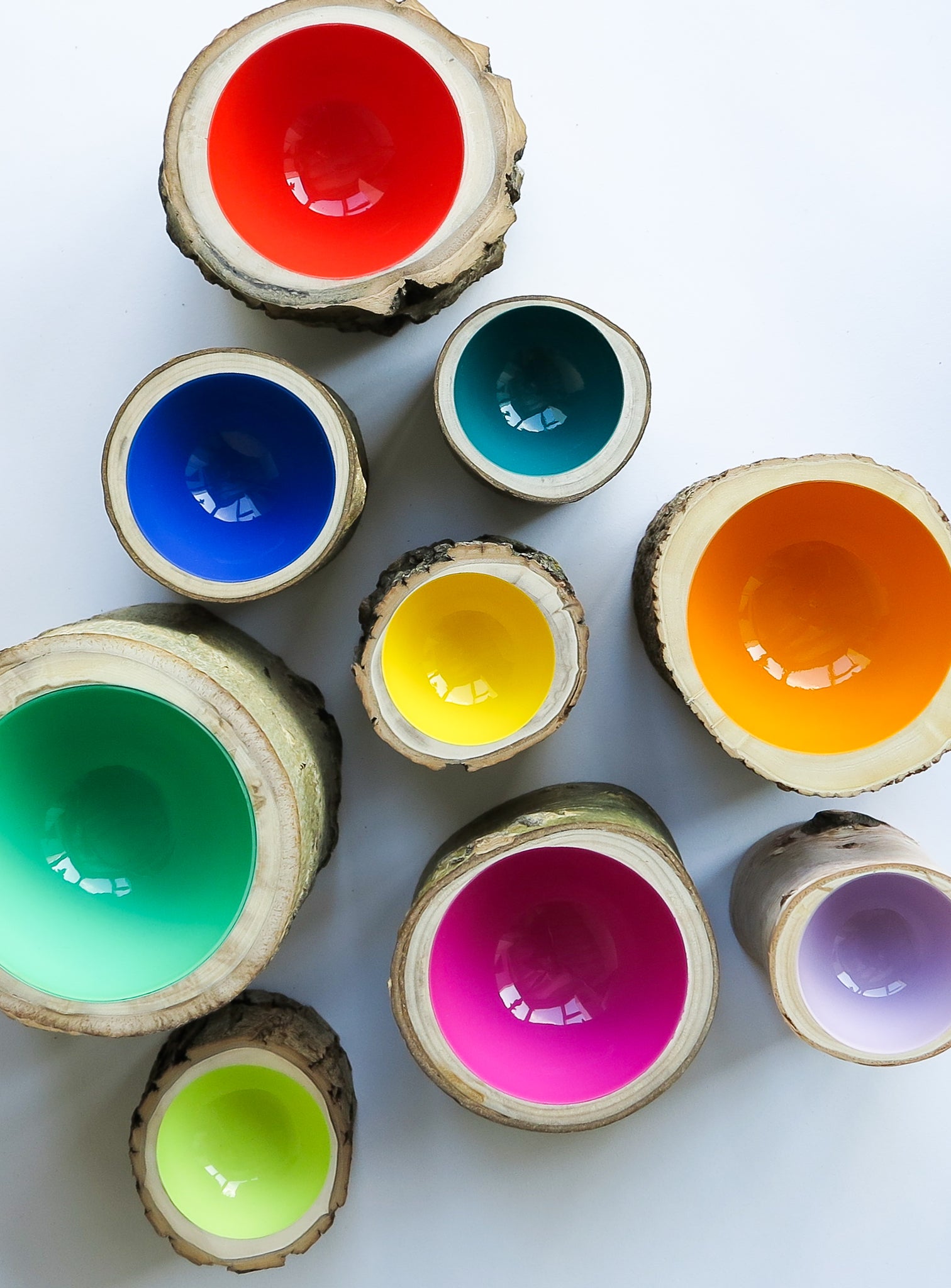 Group of 9 wood Log Bowls by Loyal Loot in various sizes in bright colours including celery green, mandarin orange, magenta pink, lilac, aqua, cobalt, poppy red, lemon yellow and turquoise.